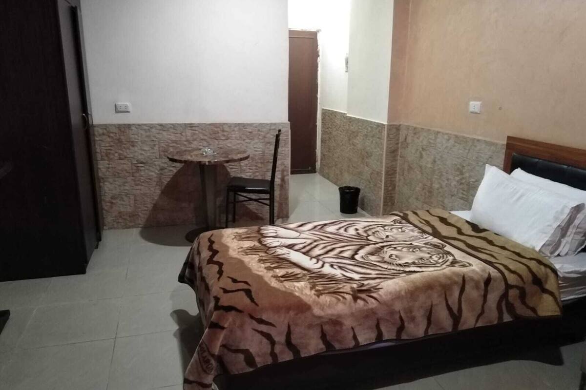 Une chambre d’hôtel avec un lit, une petite table ronde et une chaise.