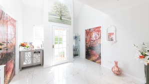 A bright hallway with white walls, a marble floor, and artwork depicting trees. - JustB (Edinburgh)