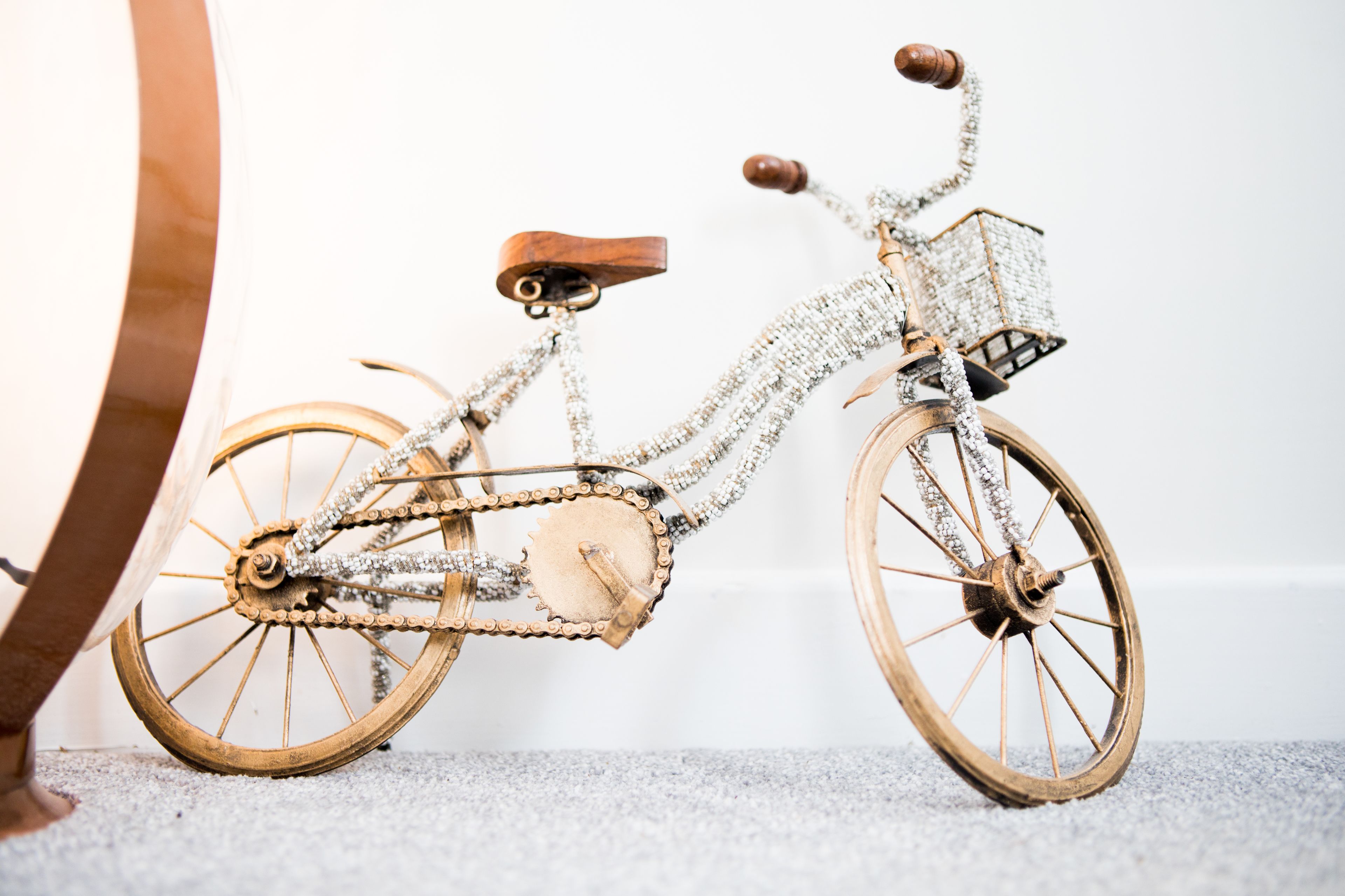 A vintage bicycle with a wooden frame and chainmail details, positioned against a plain background.
