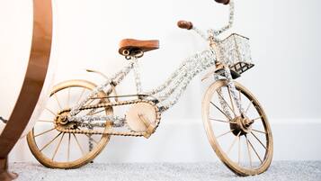 A vintage bicycle with a wooden frame and chainmail details, positioned against a plain background.