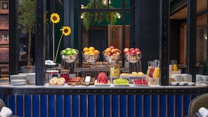 Un buffet de petit-déjeuner proposant une variété de fruits, de viennoiseries et de boissons.