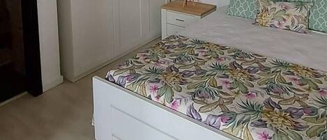 Ein Schlafzimmer mit einem Bett, einem Kleiderschrank und einem Nachttisch.