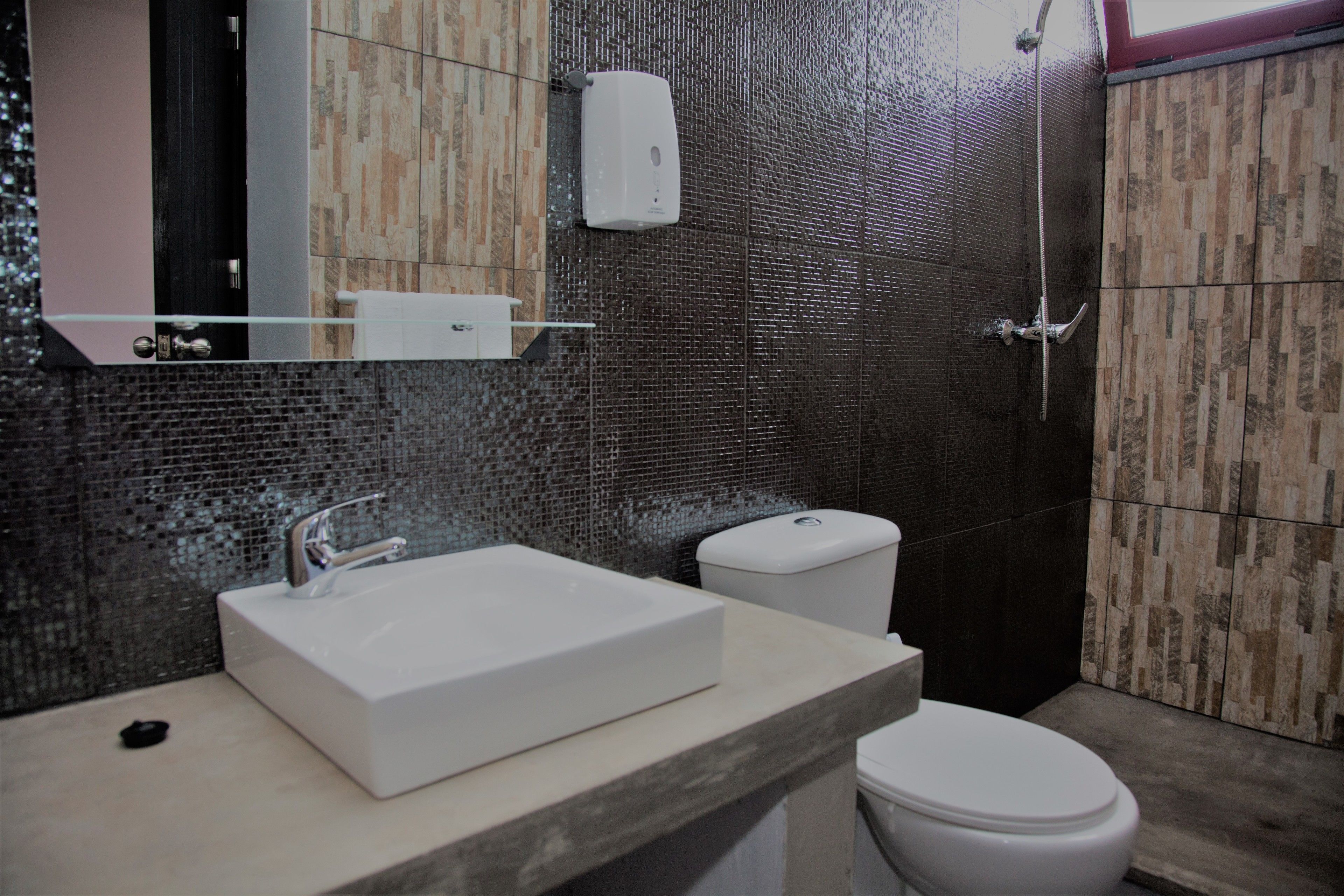 Un bagno moderno con un lavabo rettangolare, un water e una doccia.