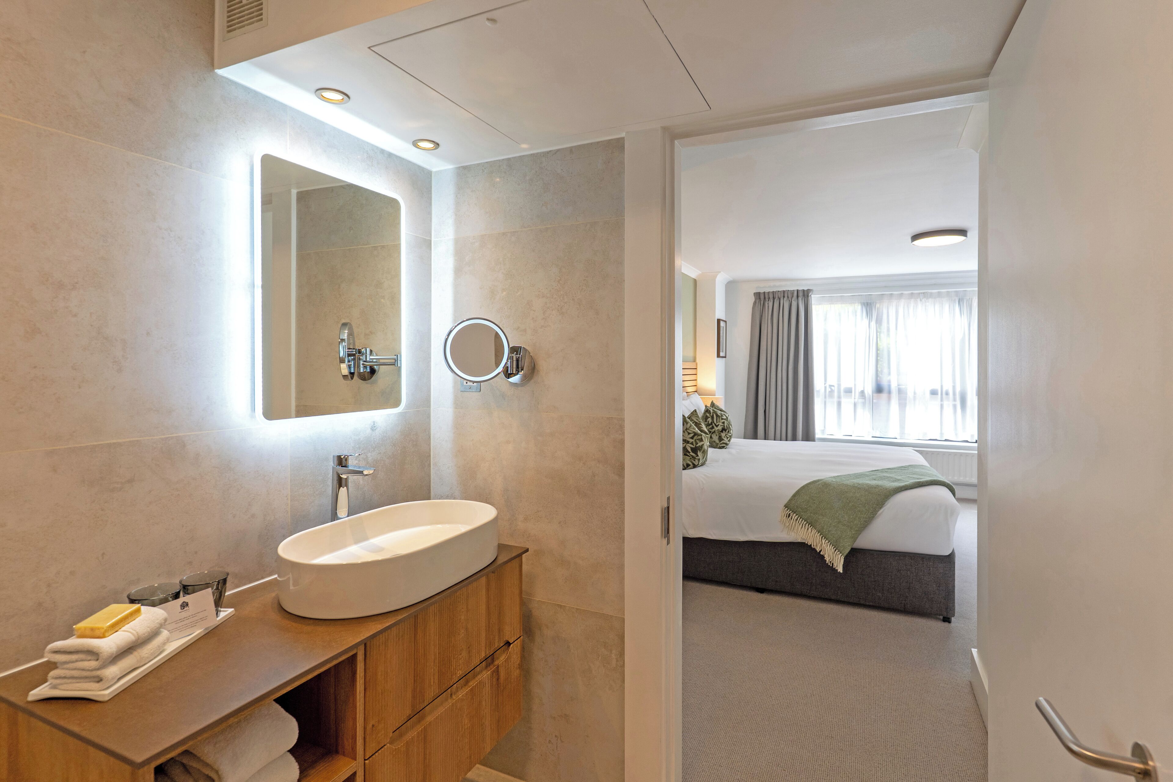 Un baño moderno con un lavamanos grande, un espejo y un mueble de tocador de madera.