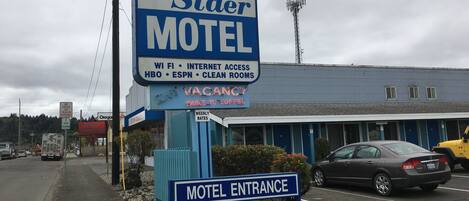 Letrero de motel que ofrece comodidades como WiFi, acceso a internet, HBO, ESPN y habitaciones limpias.