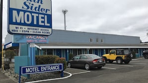 Un motel con un cartel que indica WiFi, acceso a internet, HBO, ESPN y habitaciones limpias.