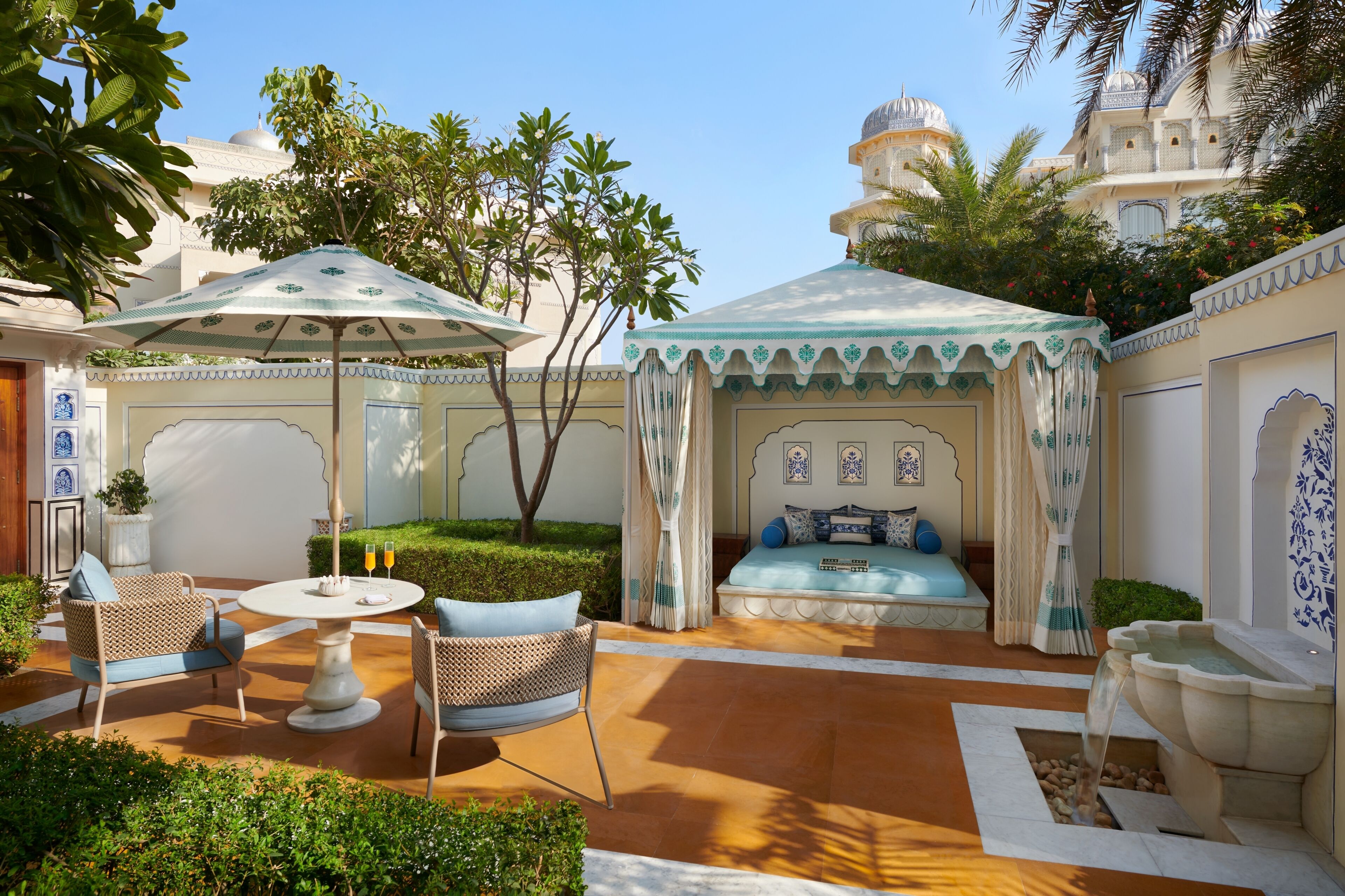 A courtyard with a seating area, a table, and a decorative umbrella.
