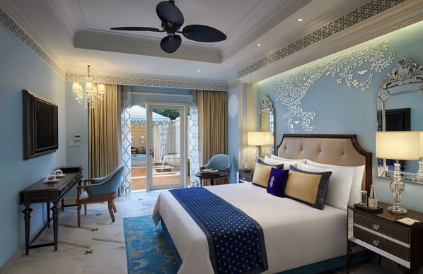 Une chambre d’hôtel spacieuse, dotée d’un grand lit, d’un bureau et d’une chaise. Elle dispose également d’un balcon avec vue sur l’extérieur.