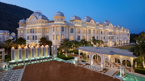 A grand hotel with multiple domes, a spacious courtyard, and a well-maintained garden.