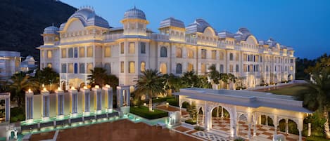 A grand hotel with multiple domes, a spacious courtyard, and a well-maintained garden.