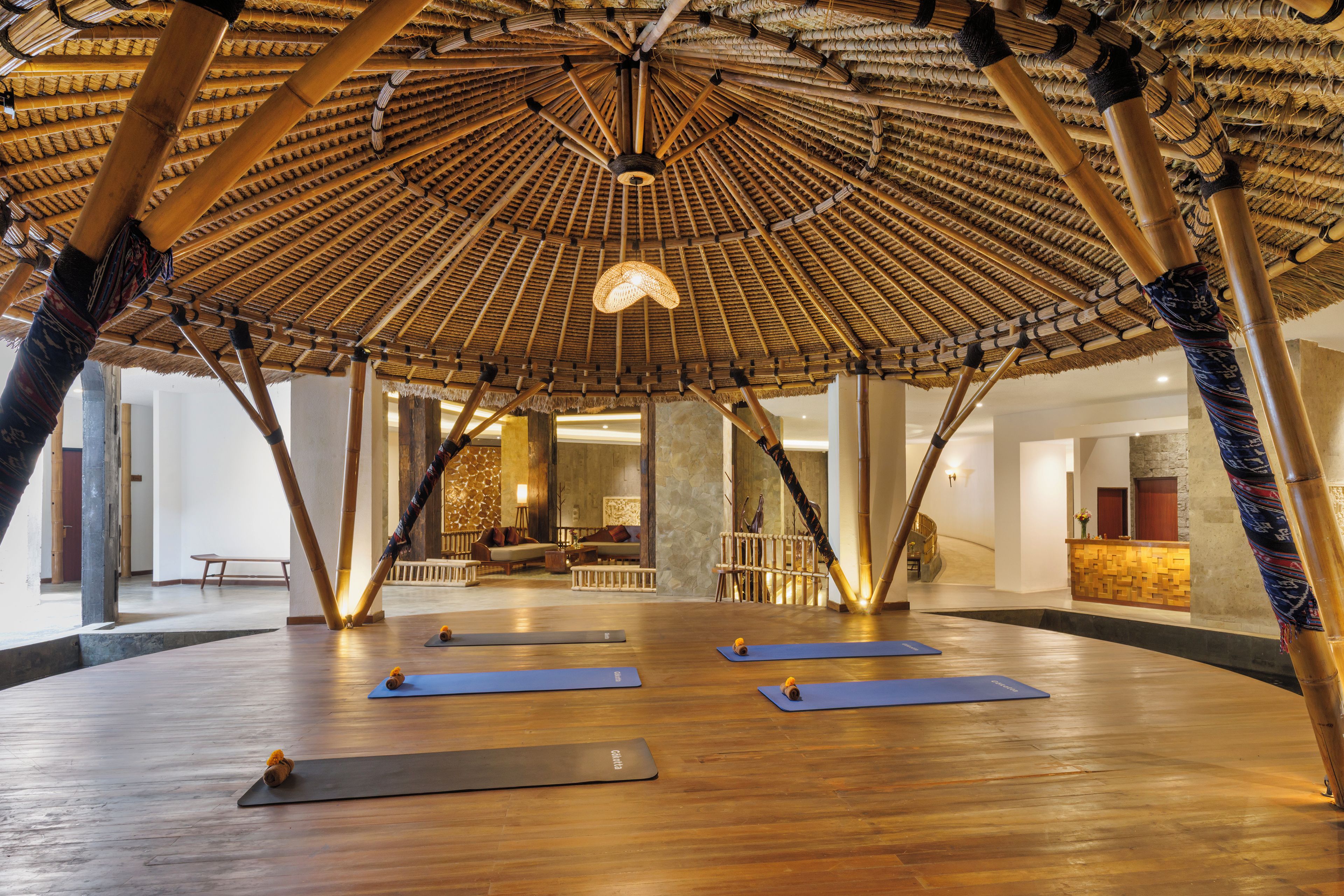 A spacious room with a high ceiling, a central open area, and a seating arrangement.