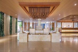 A spacious lobby with a reception desk, a decorative wooden ceiling, and a stone fountain. - Wyndham Dreamland Resort Bali (Pecatu)