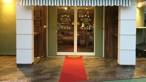 A hotel entrance with a red carpet leading to a room labeled "Soba Room Vida". - Guest House Vida (Belgrade)