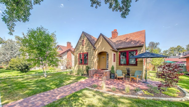 A house with a brick pathway leading to a patio area with outdoor furniture. - 1936 Keystone Cottage - Family Friendly (Boise)
