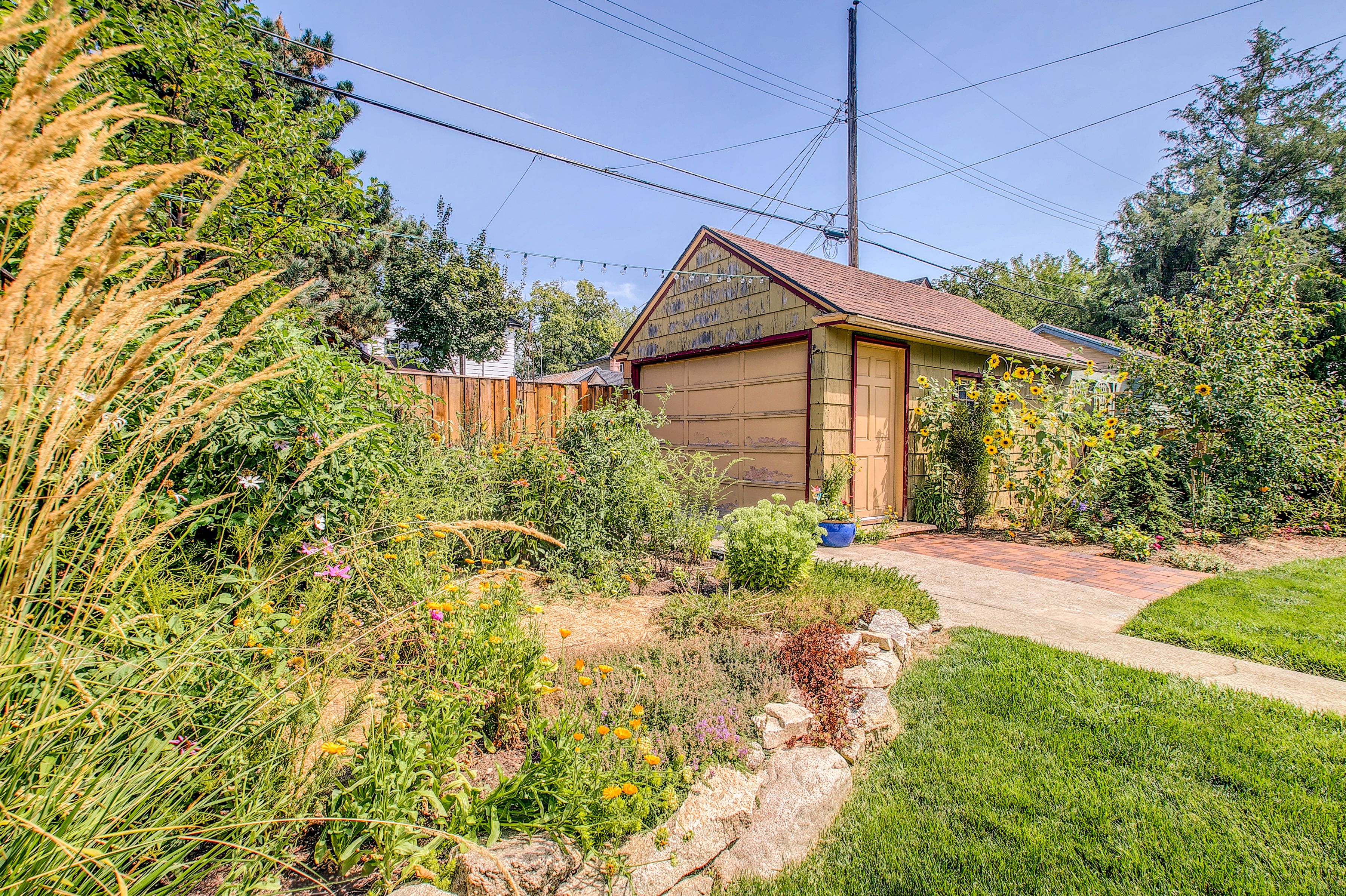 A residential property with a garage, garden, and wooden fence.
