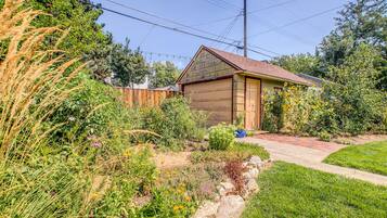 A residential property with a garage, garden, and wooden fence.