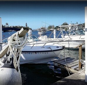 A marina with boats docked, a wooden dock, and a clear blue sky. - Lemon and Ginger (Pembroke Parish)