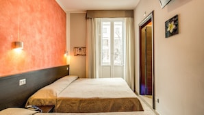 A hotel room with two beds, a large window with curtains, a wall-mounted TV, and a door to the elevator. - Buonarroti Suite (Rome)
