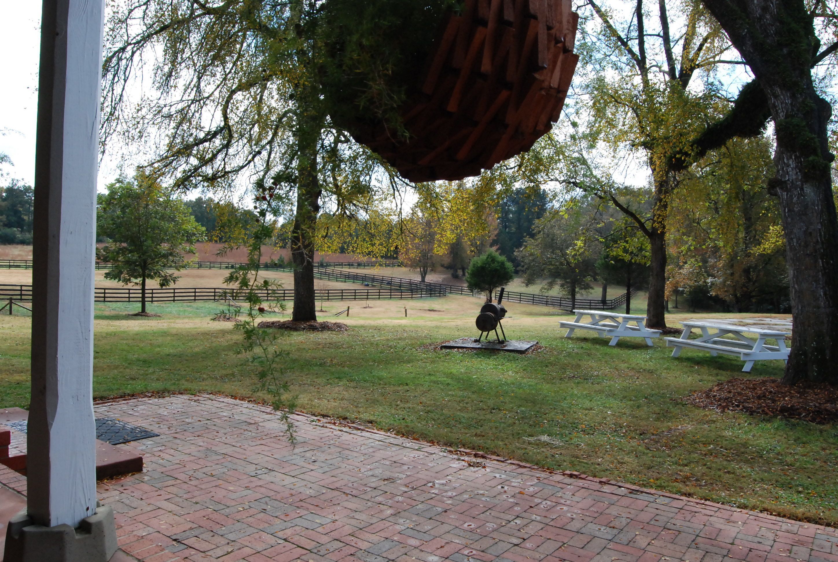 A park with picnic tables, a statue, and a hanging planter.