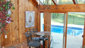 A wooden interior with a glass door leading to a pool area. - The Colonels B&B and Inn (Athens)