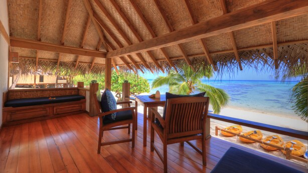 A wooden deck with a thatched roof, overlooking a beach and ocean. - Etu Moana Boutique Beach Villas - Adults Only (Aitutaki)