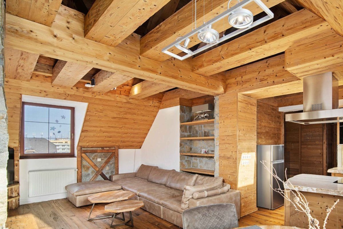 Een gezellig houten interieur met een hoekbank, een eettafel en een keukenhoek.