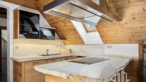 A modern kitchen with a large island, wooden cabinetry, and a skylight.