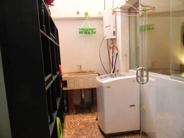 A compact laundry room with a washing machine, a sink, and a mirror. - Hatun Wasi Tawantinsuyo (Cusco)
