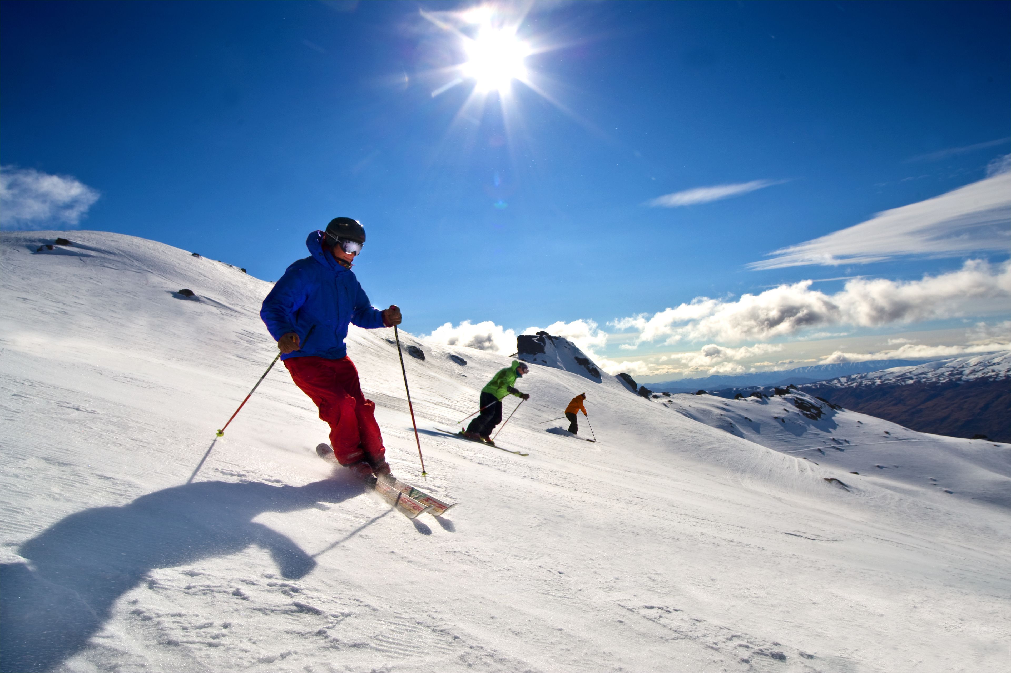 A snowy mountain slope with skiers.