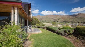 Uma casa moderna com um deck de madeira e vista para as montanhas.