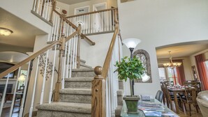 Un escalier avec des balustrades en bois et une plateforme recouverte de moquette.