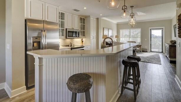 A modern kitchen with a central island, stainless steel appliances, and pendant lighting. - Unit 405, 2BR on Rooftop Pool Floor, Steps to Coligny, SeaCrest Pool Access (Hilton Head Island)
