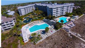 A resort with multiple swimming pools, a large central pool, and a landscaped area with lounge chairs. - Unit 405, 2BR on Rooftop Pool Floor, Steps to Coligny, SeaCrest Pool Access (Hilton Head Island)