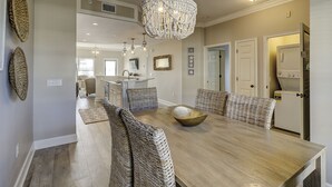 A spacious dining area with a large wooden table, wicker chairs, and a central bowl. - Unit 405, 2BR on Rooftop Pool Floor, Steps to Coligny, SeaCrest Pool Access (Hilton Head Island)