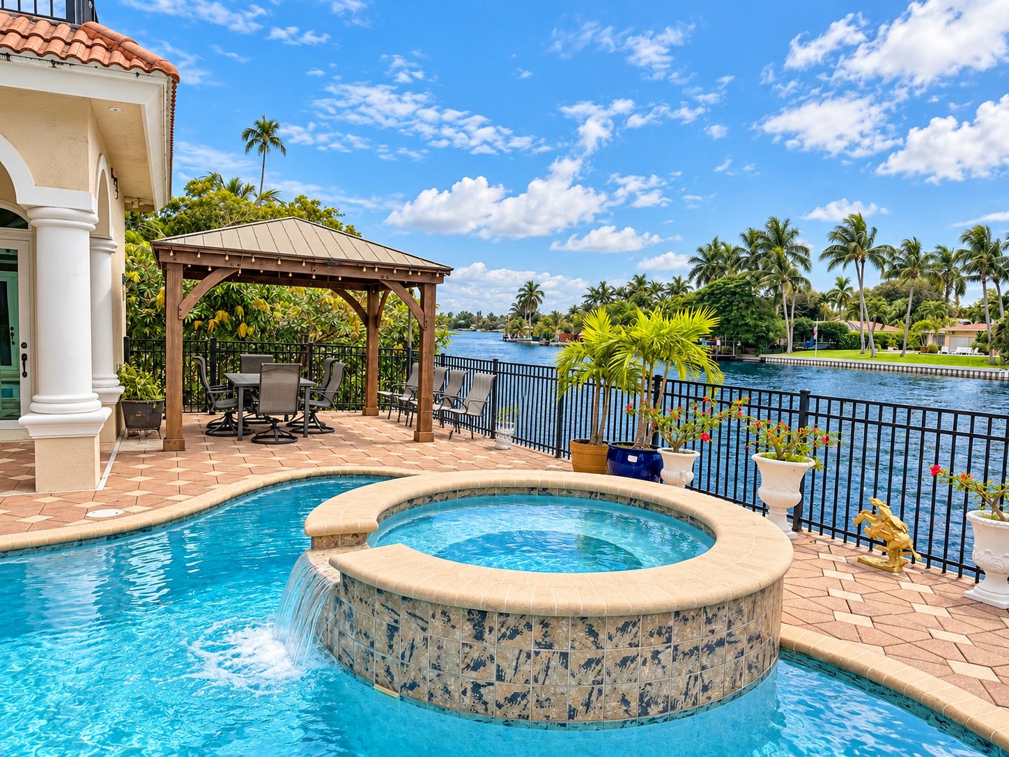 A swimming pool with a hot tub, outdoor seating, and a view of the water.