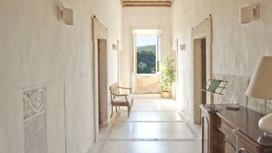 A corridor with a bench, a potted plant, and a desk with a lamp. - Renaissance Villa of the Aqueduct 1hr from Rome. Lazio-Umbria border  (Orte)