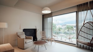 A modern living room with a sofa, chairs, a coffee table, and a hanging swing chair.