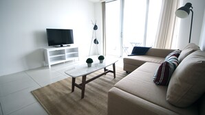 Signature-Apartment, 1 Queen-Bett und Schlafsofa, Balkon, Buchtblick | Wohnzimmer | Flachbildfernseher