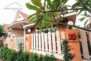 A villa with a white fence, a red flower decoration, and a balcony with a lamp. - Hansa Paradise Hill Pool Villa (Pattaya)
