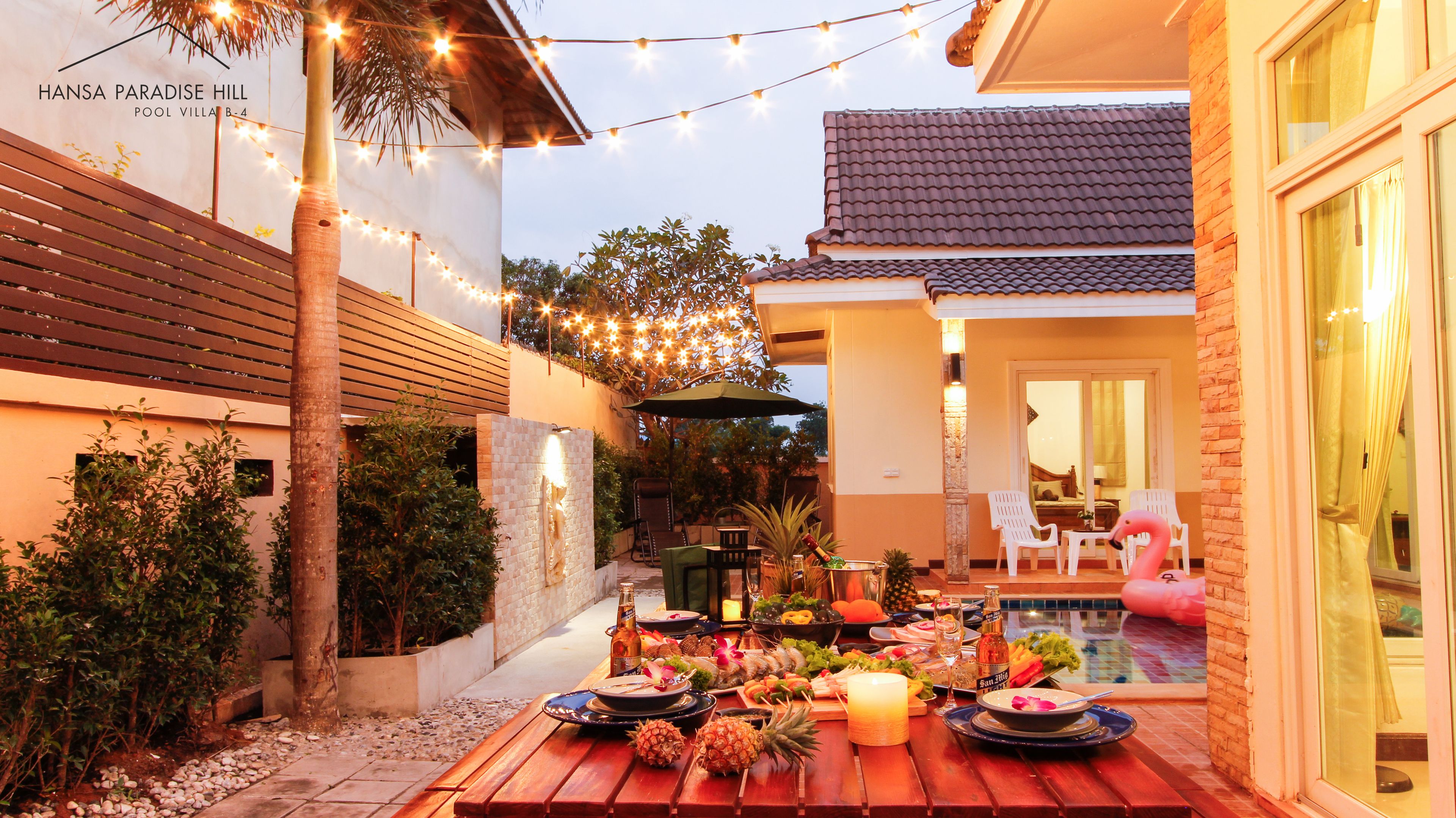 A patio with a dining setup featuring a table, chairs, and a pool.