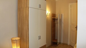 A room with a wardrobe, a mirror, and a lamp.