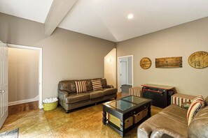 A living room with a brown leather sofa, a glass coffee table, and a pool table. - "On the Rocks"  Bourbon Trail Getaway (Taylorsville)