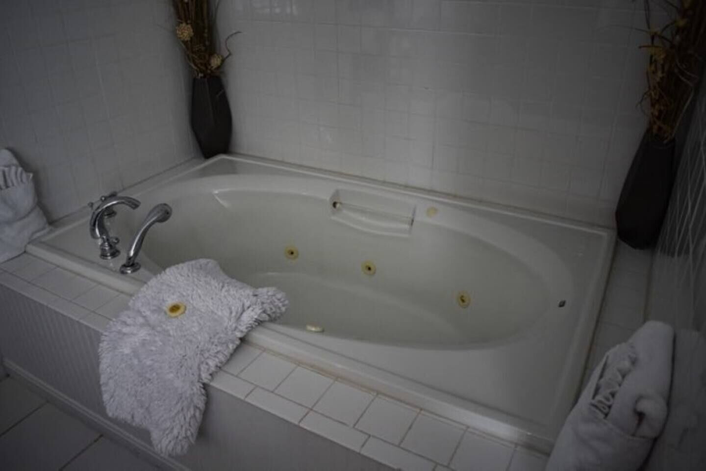 A bathroom with a bathtub, a sink, and a towel rack.