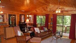 A wooden cabin interior with a living room, dining area, and a kitchen. - Two bedroom cabin, King Beds, WI-FI, hot tub, pool, views (Pigeon Forge)