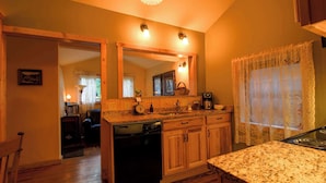 A kitchen with wooden cabinets, a granite countertop, a dishwasher, and a coffee maker.