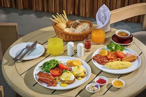 A round table with breakfast plates, including eggs, bacon, toast, and vegetables. - The Park Nine Hotel Suvarnabhumi  (Bangkok)
