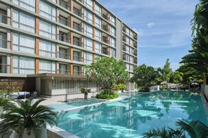 Una piscina al aire libre, sillones reclinables de piscina