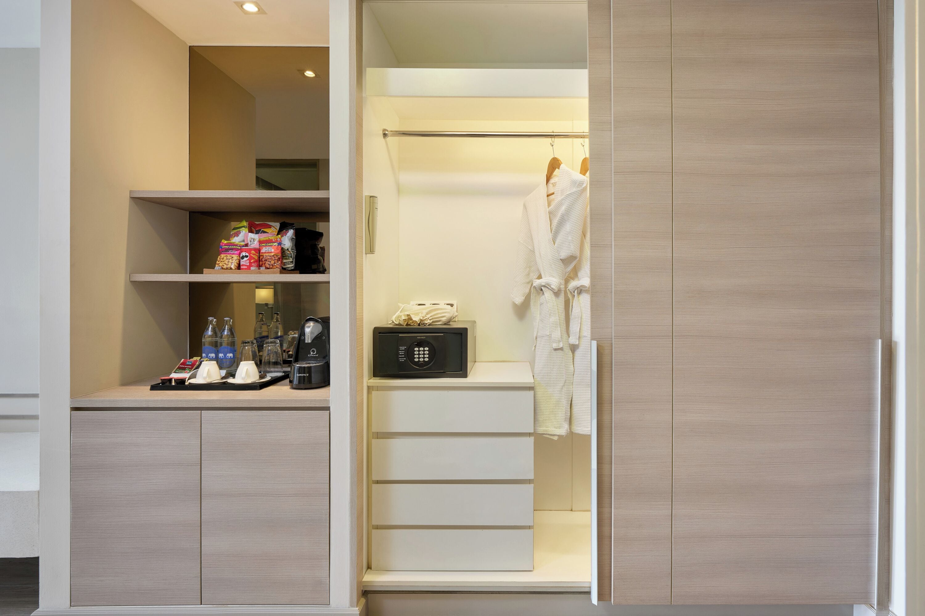 A modern bathroom with a walk-in shower, a robe hanging on a rack, and a shelf with toiletries.