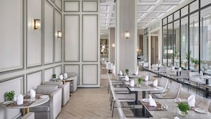 A modern hotel dining area with high ceilings, large windows, and a clean, organized layout. - The Park Nine Hotel Suvarnabhumi  (Bangkok)