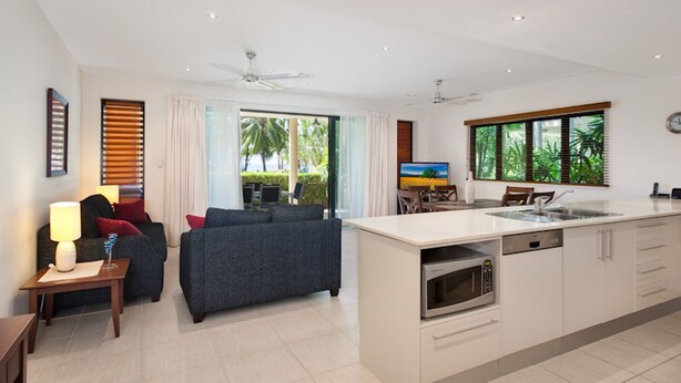 Una habitación de hotel moderna con sala de estar, comedor y cocina.